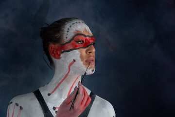 Studio portrait of woman painted on body, body paint with ethnic drawing