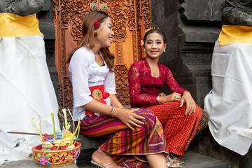 Obraz premium Two young girls in traditional clothing, Pura Candidasa is a gorgeous Hindu Balinese temple, Bali.