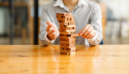 Businesswoman protects wooden block fall to planning and strategy in risk to business Alternative...