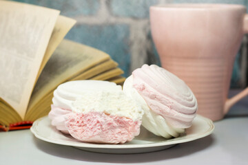 Pink and white marshmallows, a cuo of tea, a healthy dessert