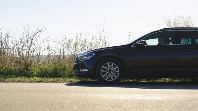 Mature business man in black suit sitt in broken car talking on mobile. Male driver calling someone for help during problems on road. Car accident. Car trouble
