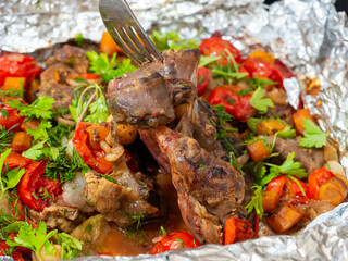 Close-up of delicious juicy veal meat baked in the oven with vegetables and decorated with fresh herbs. Food background. A delicious and healthy dish