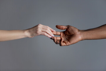 Gentle touch of female and male on grey background.