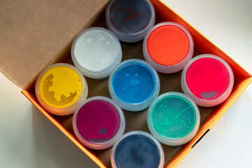 Open box with multi-colored paints. Gouache paint in a carton box