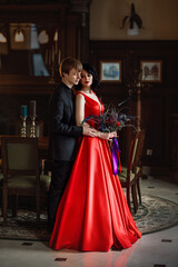 Naklejka premium woman in a red dress with a man in a black suite