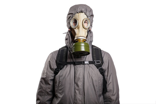 An isolated shot of a man dressed in a gas mask, a jacket with a hood, a backpack, gloves, looking into the camera. On a white isolated background