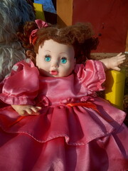 abandoned unnecessary doll in a beautiful pink dress
