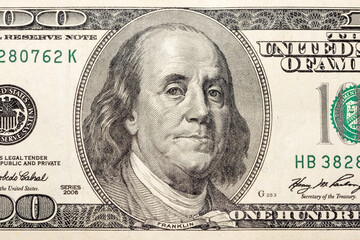 Benjamin Franklin's face in close-up on a US hundred dollar bill.