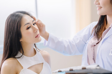 Plastic surgeon / plastic surgery examining a beautiful woman's face hand touch Examine the recovered face after the surgery with amazing results.