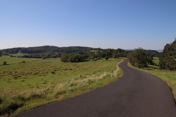A road in the landscape surrounded by meadows and trees near Usti nad Labem, Czech republic