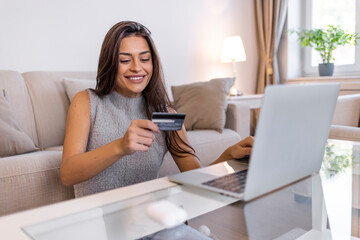 Beautiful woman shopping online at home. Young woman relaxing on a floor while doing online shopping on a laptop at home. Online payment. Young woman paying online with credit card and lap top at home