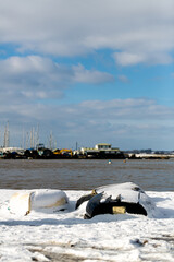 Upturned row boats have been left moored on the beach on the Suffolk coast. They have been covered in snow after a rare snow storm covers the area