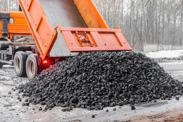 Dump truck in the industrial zone unloads coking coal from the body - obrazy, fototapety, plakaty