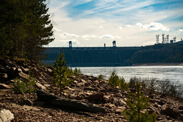 Rocky river bank against the background of the hydroelectric power station.