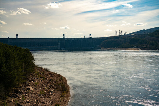 Rocky river bank against the background of the hydroelectric power station.