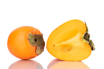 One whole and one half sweet organic persimmon, close-up, isolated on white.