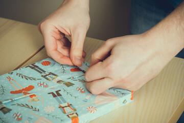 Close up of christmas gifts. Male hands wrapping gifts, christmas gifts concept. 