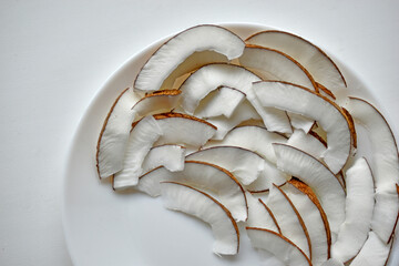 Slicing and shavings of coconut on a white plate