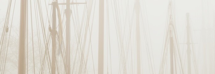 Elegant and modern yachts, sailing and fishing boats moored ti a pier in a fog. Mast silhouettes....