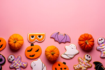 Homemade Halloween cookies, pumpkins, ghosts, bats, skeletons on pink background