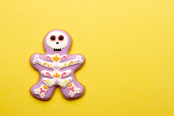 Homemade Halloween cookies in the form of cute skeletons on a yellow background