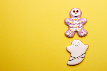 Homemade cookies cute skeletons and ghosts for Halloween on yellow background