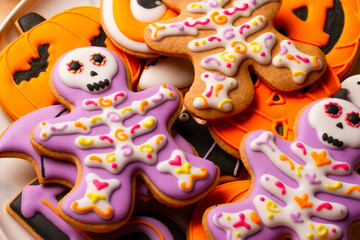 Homemade cookies cute skeletons, ghosts, bats and pumpkins for Halloween on a plate closeup
