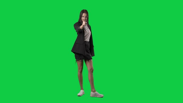 Back view of woman in suit jacket turning at camera picking you. Slow motion. Full body isolated on green screen background