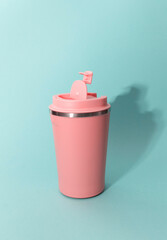 Pink thermo coffee mug on blue background