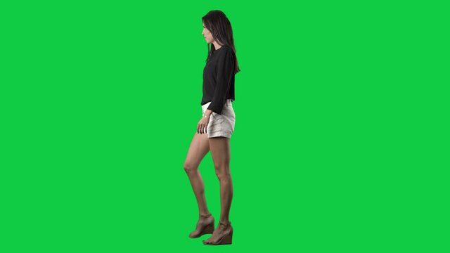 Serious confident young business casual style woman walking in hurry. Side view. Full body isolated on green screen background