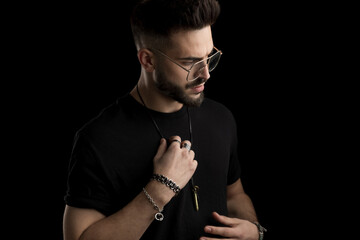 dramatic unshaved young man with glasses looking to side