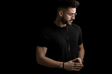 sexy young fashion man with glasses looking to side and touching fingers