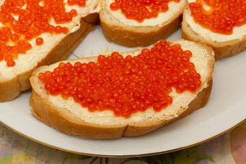 Traditional Russian snack white buns with butter and red fish caviar