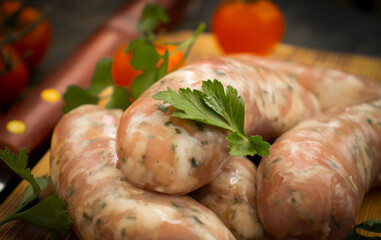 raw sausages, tomato on wooden background 