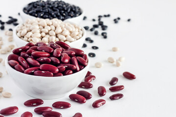 Assortment of beans in a white bowl on white background