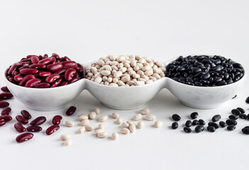 Assortment of beans in a white bowl on white background