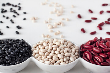 Assortment of beans in a white bowl on white background