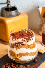 Tiramisu espresso coffee ladyfinger Italian traditional food sweet dessert homemade bakery in glass with beans short grinder	