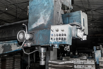 Old milling machine tool with control panel and buttons and equipment for metalworking in the workshop of an industrial plant