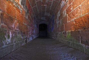 Dunkler gemauerter Tunnel, Backstein, Tunnel führt ins dunkle Nichts