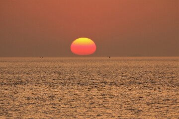 an enchanting yellow and red sun just above the water of the westerschelde sea at the dutch coast...