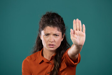Woman showing stop sign gesture with palm in studio