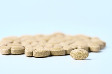 Daily vitamins on a light background. Light brown pills