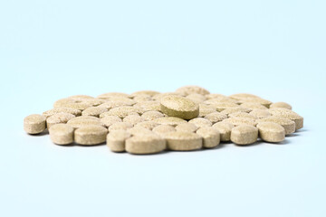 Daily vitamins on a light background. Light brown pills