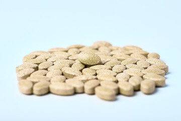 Daily vitamins on a light background. Light brown pills