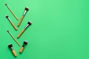 Set of professional makeup brushes on color background