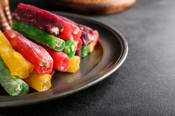 Plate with tasty Turkish delight on dark background