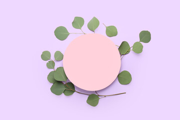 Blank paper sheet and eucalyptus branches on color background