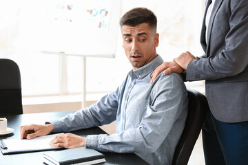 Man harassing his male colleague in office