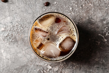 Glass of tasty iced coffee on grunge background